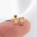Close-up of a 1.0cm gold heart cartilage stud earring held on a fingertip for scale - Gold-White Heart