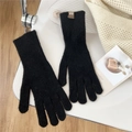 Detail of black knitted gloves with vertical rib texture and small leather logo patch - One Size / Black