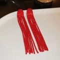 Nahaufnahme glitzernder roter Strass-Ohrringe mit langen Fransen auf Keramiktablett - Rot (Qualle)