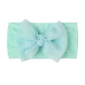 Detail shot of a baby nylon headband with a large soft mint green decorative bow - Mint Green