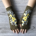 Close-up of olive green knitted fingerless gloves with yellow flower embroidery details - Army Green