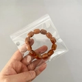 Brown beaded bracelet stored in a portable clear PVC self-sealing jewelry storage bag - 30 Micron 10.5x11cm Resealable / 100 Pcs/Pack