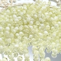 Macro detail of 10mm yellow cracked glass beads for DIY jewelry making on white tray - 8mm Semi-white Yellow