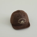 Dettaglio ravvicinato del cappellino marrone in cotone per neonati con ricamo orsetto e visiera morbida - 48-50cm (1-2 anni) / caffè