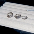 Detailed close-up of three sparkling zircon ear cuffs on a soft beige velvet jewelry tray - Silver Crisscross Style (Set)