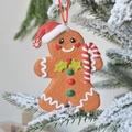 Χριστουγεννιάτικο στολίδι ανθρωπάκι gingerbread με κόκκινο σκούφο σε χιονισμένο δέντρο - Gingerbread Man με μπαστούνι γλυκό