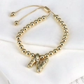 Detail of adjustable gold bead bracelet featuring a sparkling zircon letter N pendant - Letter N