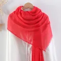 Red cotton linen scarf with frayed edges and pleated texture on a wooden hanger - Red