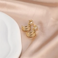 Macro shot of gold-plated curved metal earrings with a rectangular zircon on champagne satin - Gold (E00288-1)