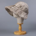Detail eines beigen Sonnenhuts mit breiter Krempe und elegantem Knotendetail aus Stoff - Khaki