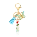 Handmade emerald butterfly keychain with light blue tassel and resin dried flower charm - Letter I