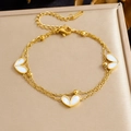 Close-up of double-layered gold stainless steel chain bracelet with heart charms - White Shell Heart Bracelet (B2027)