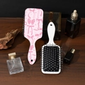 Detalle del cepillo de pelo rosa con lazo y peine blanco sobre un escritorio de madera - Estilo D# Lazo Rosa Blanco