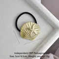 Detail view of golden starfish and shell hair tie in a white velvet display box - Gold Scallop Starfish