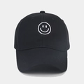 Primer plano del bordado de cara sonriente blanca en una gorra de béisbol negra - Negro