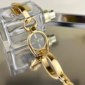 Close-up of gold metal bracelet watch with black dial and Roman numerals on reflective surface - Gold Case Black Dial