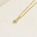 Collana con pendente a mano di Fatima dorata e zircone rotondo su fondo materico - Mano di Hamsa Zirconia
