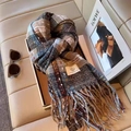 Blue and beige plaid checkered scarf with tassels on a leather sofa display - Coffee Plaid