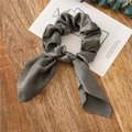 Grey satin rabbit ear hair scrunchie with long ribbons on a wooden surface - Dark Gray