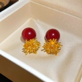 Close-up of red geometric stud earrings with gold sunburst design and sparkling rhinestones - Radiant Flower Cluster Red