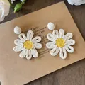 Detalle macro de pendientes de margarita en rafia sobre tarjeta vintage - Estilo Margarita / Blanco Roto-Amarillo (2# Pin de Acero)