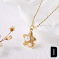 Dettaglio macro del ciondolo a stella marina dorata con perle bianche e catena a sfere - Stella marina / Oro