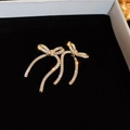Boucles d'oreilles nœud dorées avec pampilles en zircone et finitions scintillantes - Noeud à Long Pompon Doré