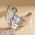 Vista detallada del brazalete de plata con textura martillada sobre roca natural - Plateado