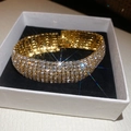 Nahaufnahme eines luxuriösen vergoldeten 4-reihigen Strass-Armreifs, der in einer Box glänzt - Vierreihiger Pavé-Strass Stil (20#) / Gold