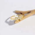 18k vergulde verstelbare ring met een zirkonia strik op een houten tak gepresenteerd - Goud