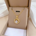 Dettaglio di una collana a luna dorata con zirconi in una scatola per gioielli beige - Pendente a Luna Dorata con Micro-incastonatura (H522)