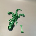 3D printed green T-Rex skeleton toy model with articulating joints and a bone accessory - Green