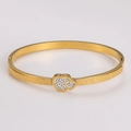 Detailed macro view of gold heart bangle with sparkling sand finish and pave set crystals - Gold