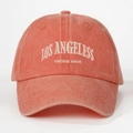 Close-up of Los Angeles white embroidery on coral orange washed cotton baseball cap - Orange