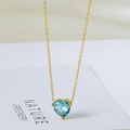 Elegant 18k gold heart necklace featuring a blue faceted gemstone pendant on a white card - Gold with Light Blue Rhinestone