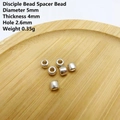 Detalle macro de cuentas espaciadoras de plata de 5mm con dimensiones en madera - Plata 5x4mm
