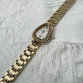 Detalle macro de reloj de serpiente dorado con esfera romana y correa de eslabones - Esfera Blanca Dorada