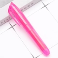 Roze highlighter pen met doorschijnende behuizing en clip op een witte geruite ondergrond - Roze