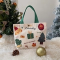 Cartoon Christmas canvas tote bag with festive prints and green handles in creamy white - Christmas Gift