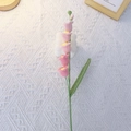 Handmade crochet Lily of the Valley flower in pink yarn on white fabric background - Single Stem Finished / Gradient Pink
