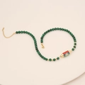 Detail of malachite beaded necklace with gold LOVE pendant and enamel eye motif - Green Malachite Style (LOVE/Rainbow/Eye)