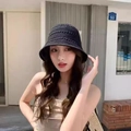 Women's black hollow crochet knit bucket hat shown on a model in an outdoor setting - Hollow Out / Black