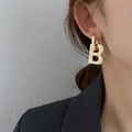 Fashionable gold letter B chunky hoop earrings with polished metallic finish on a model - Letter B Drop Earrings - Gold