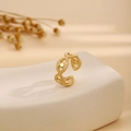Goldener offener Ring mit hohlem Augenmuster und Perlendetail auf einem Steinständer - Hohler Punktierter Stil