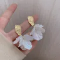 Elegant gold shell flower drop earrings with translucent white petals and hammered metal finish - Shell Flower Gold Sequin Studs
