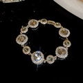 Detail eines silbernen geometrischen Schmucksets mit funkelnden Kristallen auf Schwarz - Armband - Gold - Grau