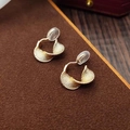 Elegant gold spiral texture clip-on earrings on a premium brown velvet base display - Gold Spiral Textured Ear Clip