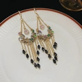 Close-up of golden tassel earrings with multi-colored crystals and black beads on a dish - Colorful Gemstone Chain Tassel (17#)