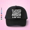 Μαύρο καπέλο trucker με τύπωμα TANNED and TIPSY και ρυθμιζόμενο λουράκι σε ροζ φόντο - Μαύρο