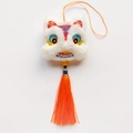 Détail du pendentif lion de danse en peluche blanche avec broderie et pompon orange - Lion de Fortune / Rouge & Blanc
